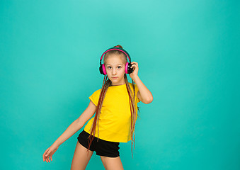 Image showing The attractive girl with headphones on blue background