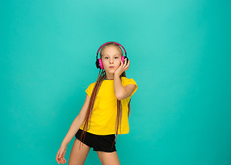 Image showing The attractive girl with headphones on blue background