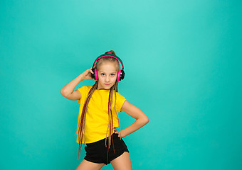 Image showing The attractive girl with headphones on blue background