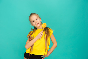 Image showing The teen girl with colorful lollipop on a blue background