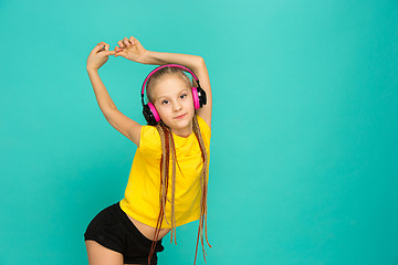 Image showing The attractive girl with headphones on blue background