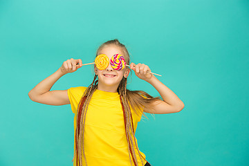 Image showing The teen girl with colorful lollipop on a blue background