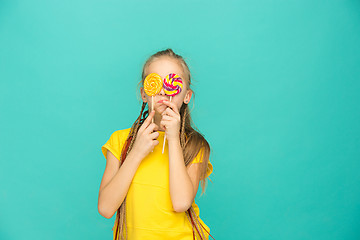 Image showing The teen girl with colorful lollipop on a blue background