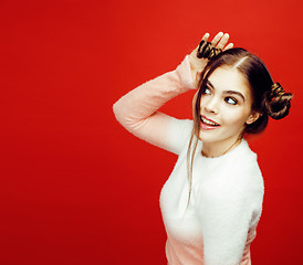 Image showing young pretty emitonal posing teenage girl on bright red background, happy smiling lifestyle people concept 