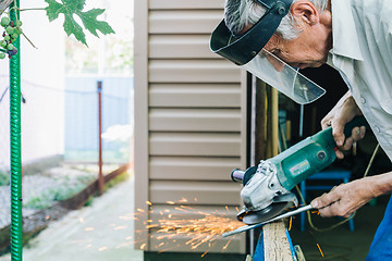 Image showing Close-up of workman working with iron