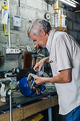 Image showing Close-up of workman working with iron