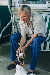 Image showing Senior man playing with dog