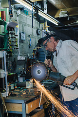 Image showing Senior man working with angle grinder