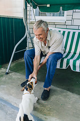 Image showing Senior man playing with dog