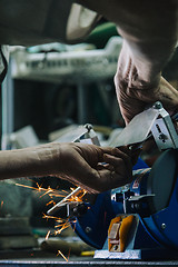 Image showing Close-up of workman working with iron