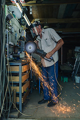 Image showing Senior man working with angle grinder