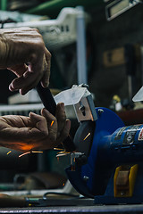 Image showing Close-up of workman working with iron