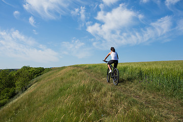 Image showing woman going for bike ride on sunny day in countryside