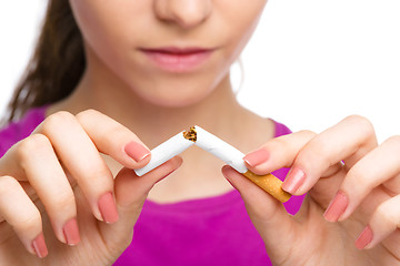 Image showing Young woman is breaking a cigarette