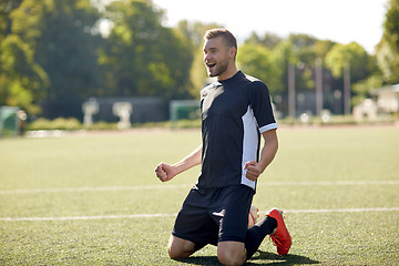 Image showing happy soccer player with ball on football field