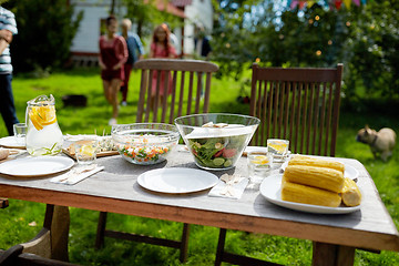 Image showing people coming to table with food at summer garden