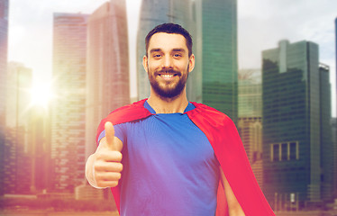 Image showing happy man in red superhero cape showing thumbs up