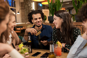 Image showing friends with drinks, credit card and bill at bar