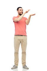 Image showing happy man holding something imaginary on hand