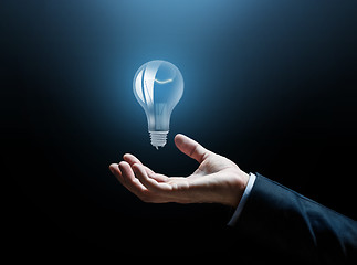 Image showing close up of businessman hand with light bulb