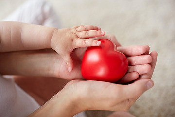 Image showing close up of baby and mother hands with red heart