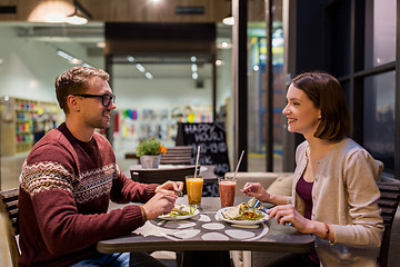 Image showing happy couple eating dinner at vegan restaurant