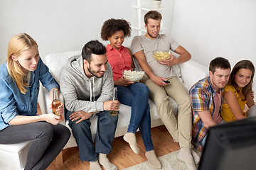 Image showing happy friends with popcorn watching tv at home