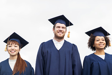 Image showing happy students or bachelors in mortar boards