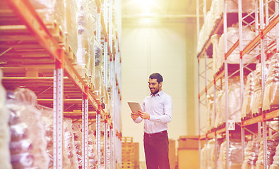 Image showing happy businessman with tablet pc at warehouse