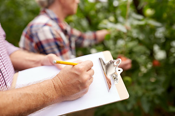 Image showing senior couple with clipboard at farm