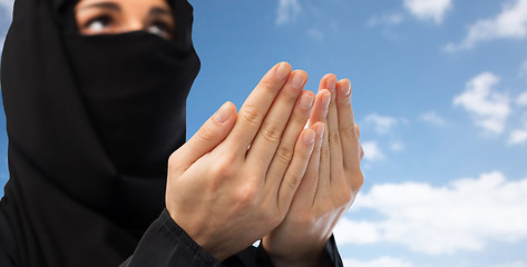 Image showing close up of praying muslim woman in hijab over sky