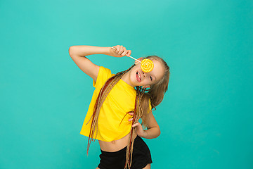 Image showing The teen girl with colorful lollipop on a blue background