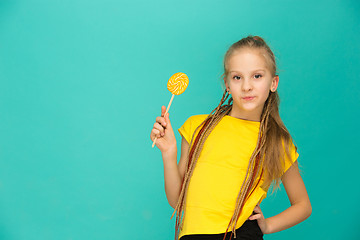 Image showing The teen girl with colorful lollipop on a blue background