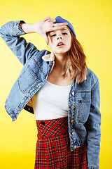 Image showing young pretty teenage hipster girl posing emotional happy smiling on yellow background, lifestyle people concept