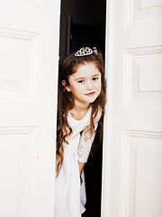 Image showing little cute girl at home, opening door well-dressed in white dre