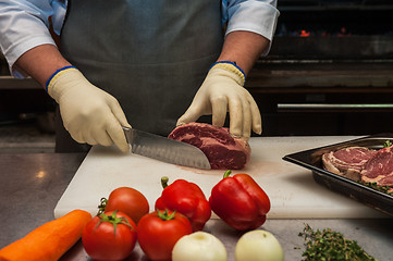 Image showing Chef cutting meat