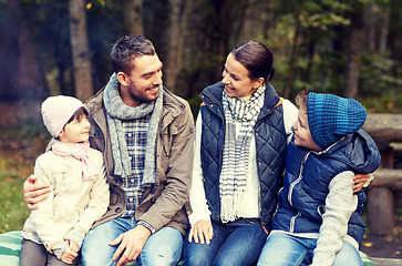 Image showing happy family sitting on bench and talking at camp