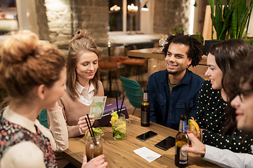 Image showing friends with drinks, money and bill at bar