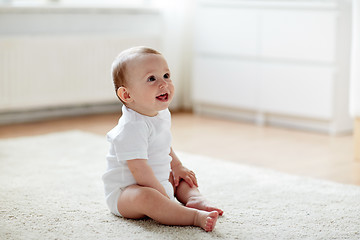 Image showing happy baby boy or girl sitting on floor at home