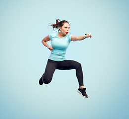 Image showing happy sporty young woman jumping in fighting pose
