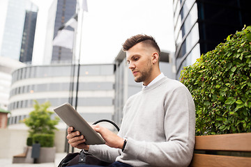 Image showing man with tablet pc sitting on city street bench