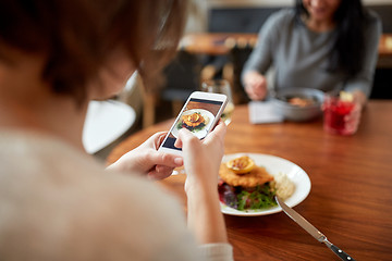 Image showing women with smartphones and food at restaurant