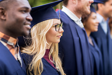 Image showing happy students or bachelors in mortar boards