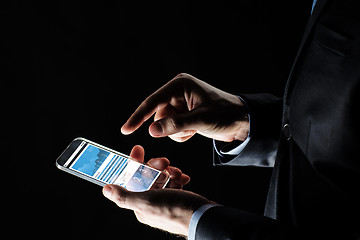 Image showing close up of businessman with charts on smartphone