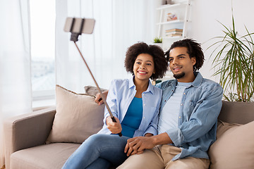 Image showing happy couple with smartphone taking selfie at home