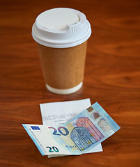 Image showing coffee in paper cup, bill and money on table