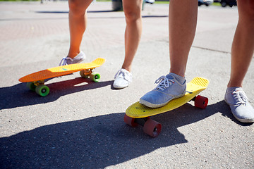 Image showing teenage couple riding skateboards on city street