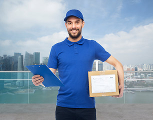 Image showing happy delivery man with parcel box and clipboard