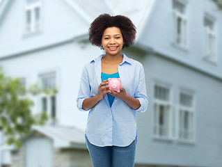 Image showing happy afro american young woman with piggy bank