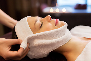 Image showing woman having face massage with towel at spa